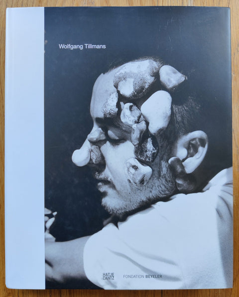 The photography book cover of Wolfgang Tillmans by Wolfgang Tillmans. Hardback with B&W image of a man with rocks on his head.