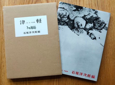 The photobook cover of Tsugaru by Yojiro Ishizaka. Paperback in B&W with red text at the bottom of the book. In a slipcase cardboard cover.