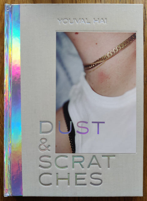 The photography book cover of Dust & Scratches by Youval Hai. In hardcover beige with chrome spine.