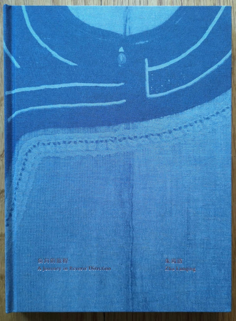 The photography book cover of A Journey in Reverse Direction by Zhu Lanqing. Hardback with denim blue cover.