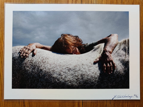 The print for photography book Dinosaur Dust by Zoe Childerley. Print of someone leaning over a horse. Signed.